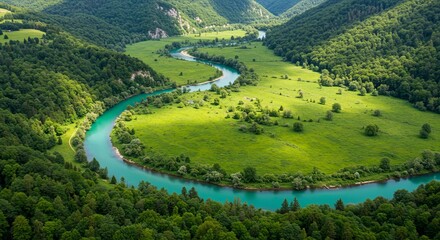 Serene turquoise river winds through lush green valley with sunlit meadows