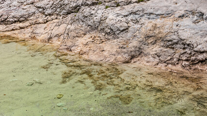 minimalist abstract background with beige rock in the crystal clear transparent river water. abstract design, warm tones. rock texture, rock