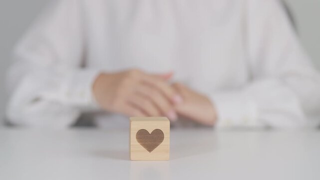 Hand holding heart block for health care, love, organ donation, charity, happy family, wellbeing and insurance concepts. world heart day, health day and mental health day