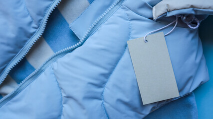 Close-up of a light blue jacket with a blank tag © shine.graphics