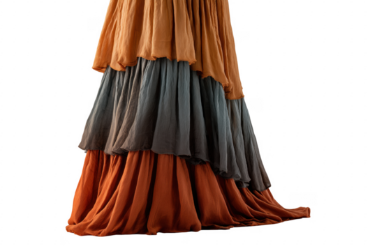 Elegant tiered layered silk gown in warm earthy tones against a deep transparent backdrop.