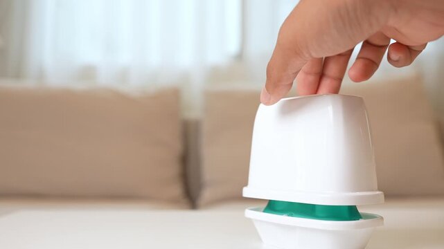 A hand opens a gel air freshener in the home, reflecting freshness, indoor air quality, odor elimination, routine care, mood enhancement, and a simple step toward healthier living spaces.
