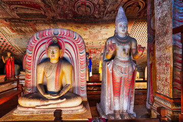 Fototapeta premium A Seated Buddha and Vishnu or Upalvan, a lankan guardian diety in Cave 3, Maha Alut Vihara at the Dambulla Cave temples built 1st centure BCE by King Valagamba and Lankan kings in Dambulla,Sri Lanka