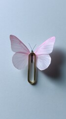 A delicate pink butterfly perched on a paperclip against a soft gray background, blending nature with office supplies in a whimsical way.