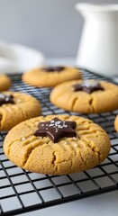 Closeup of peanut butter cookies with chocolate stars and sea salt on a cooling rack