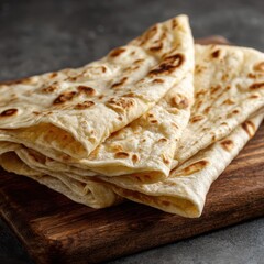 Freshly Cooked Flatbreads Piled on a Wooden Board with a Rustic Background and Golden Browned Spots on the Surface