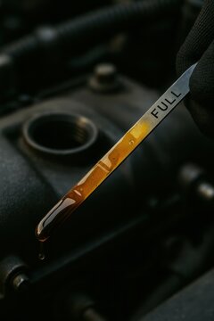Close-up of oil dipstick with lubricant level and quality check, oil testing and monitoring for automotive and machinery maintenance