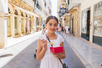 Young Girl Eating Dessert on Sunny European Street, Family Travel Moment