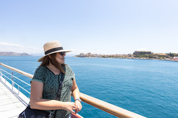 Relaxed female traveler admiring breathtaking sea views from ferry deck