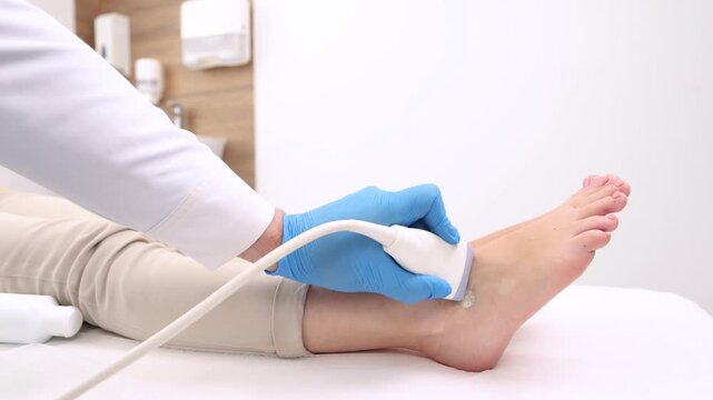 Ultrasonic of ankle joint. Sonographer checking patient ankle using high-frequency sound waves of ultrasound machine
