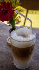 Iced Soy Milk Coffee with Flower Decoration on Wooden Table