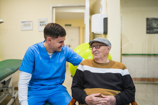 Young male nurse providing care and support to an elderly patient in a healthcare facility, promoting wellness and positive interaction