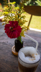Iced Soy Milk Coffee with Flower Decoration on Wooden Table