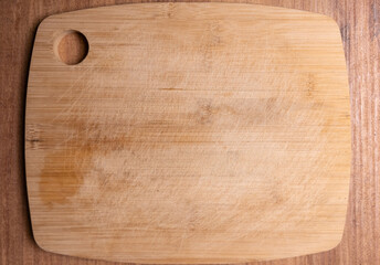 Rectangular bamboo cutting board with round hole on wooden table top