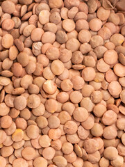 Close up of raw brown lentils as healthy legume food background