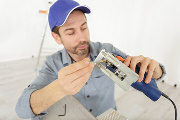 carpenter is fixing a woodworking tool