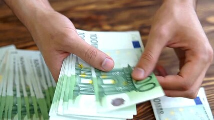 Male hands counting European 100 hundred Euro money banknotes. A man hands counting euro money bills, european economy value. Man converting euro bills manually. Euro currency exchange. - Powered by Adobe