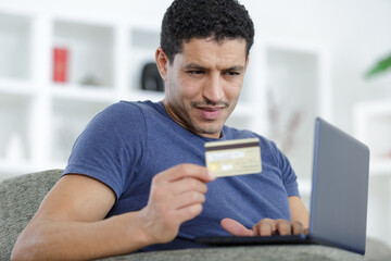 man paying with credit card on laptop