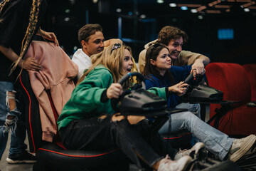 A group of friends enthusiastically engaging in a competitive racing video game experience in a fun arcade environment, enjoying the thrill and teamwork.