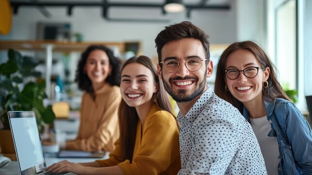 A group of smiling young professionals in a modern office setting.