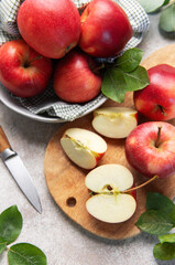 Red apples, whole and sliced, on cutting board