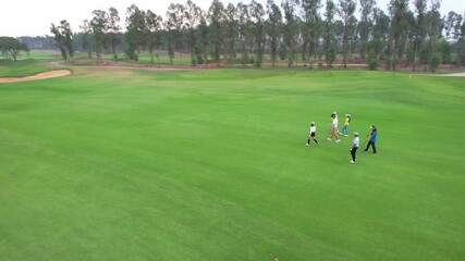 Drone view of young pro golfers swings the club on scenic golf course. - Powered by Adobe