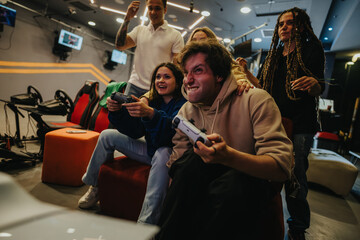 A group of friends engaged in a competitive video game match at a high-energy gaming venue, showcasing fun and camaraderie.
