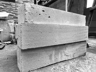 Stack of hebel concrete blocks arranged roughly on construction site. Black and white photo highlights raw texture, strength, and durability. Perfect for concept of building, industry, and progress.