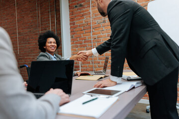 Group of colleagues shaking hands after striking a deal