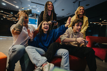 Fototapeta premium A lively group of friends enthusiastically playing a video game in a stylish, modern space, highlighting a sense of fun, togetherness, and competition.