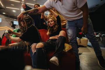 A group of enthusiastic friends passionately playing video games together in a stylish lounge setting, showcasing their energy and camaraderie while enjoying the gaming experience.