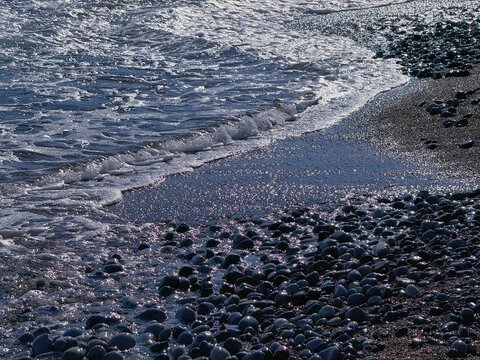 Sea waves on the pebble stones beach.