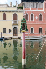 votive shrine on dockage pole in Vena canal, Chioggia, Italy