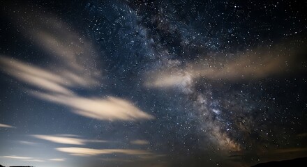 Obraz premium A breathtaking view of the night sky, filled with stars and the Milky Way, streaked with soft, pastel clouds.