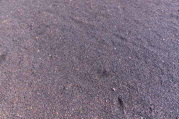 a narrow walking path in the park made of natural finely rubble, not a wide path for pedestrians to walk in the park in sunny weather
