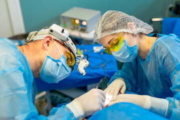 Skilled team performing surgery in a medical setting. Two medical professionals carefully conduct a surgical procedure in a clean, well-equipped operating room.