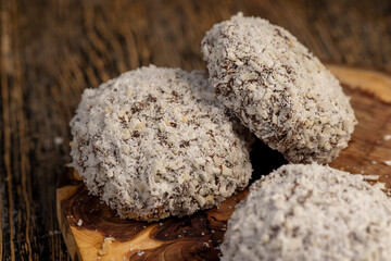 whole sweet marshmallows in chocolate sprinkled with coconut chips, sweet dessert marshmallows in milk chocolate with coconut