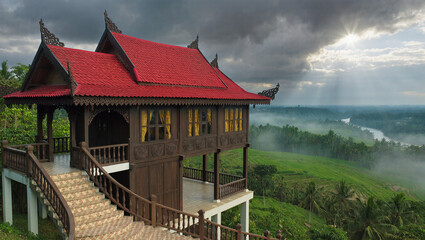 AI Generated: Traditional Malay Wooden House
A hyper-realistic cinematic wide shot of a majestic traditional Malay wooden stilt house with multiple gabled roofs. The house stands elevated on tall stil
