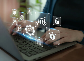 Naklejka premium Closeup of a persons hands typing on a laptop, with glowing digital icons representing business analytics and strategy floating above