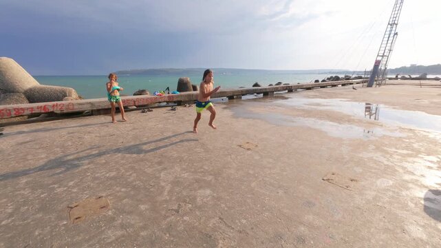 Slow motion video of an 11 year old boy jumping off a pier into the sea on a summer day, enjoying fun and freedom at the beach