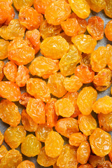 dried golden raisins, macro photo, on a stone background.