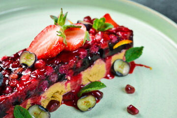 Goose pate with berry jam. Restaurant serving of food on a plate. On a black stone background. Free space for text.