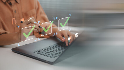 Hand using laptop with virtual checklist icons and green check marks, symbolizing task management, project approval, productivity tools, goal completion, and digital workflow organization. © FAMILY STOCK
