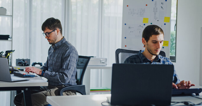 Team of male developers work code control robotics system and software automation project write prompt AI data bot at office. Artificial intelligence, collaboration, robotic, debugging, machine learn.
