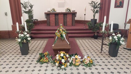 Blumengesteck mit Sonnenblumen auf Sarg