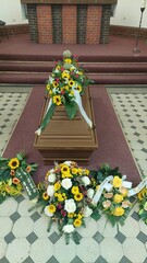Blumengesteck mit Sonnenblumen auf Sarg