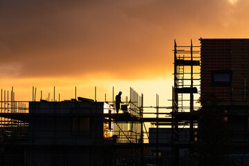 Construction workers working on a housing project in the Netherlands during a tranquil sunrise.

