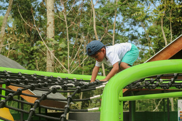 boy climbing on playground equipment