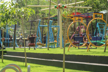 Obraz premium Blurred background of children enjoy a joyful playtime on a sunny playground, immersed in fun activities surrounded by nature, showcasing happiness and carefree moments.