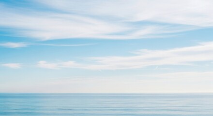 Obraz premium Serene ocean vista with tranquil waters beneath a bright, cloudy sky